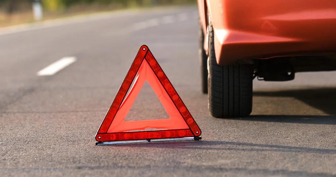 Car warning triangle next to broken down car